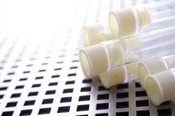 Plastic test tubes on a gridded metal surface - 784497289