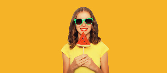 Summer portrait of happy young woman with lollipop or ice cream shaped slice of watermelon
