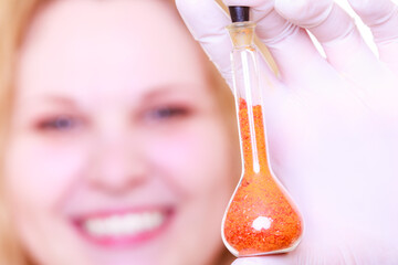 Chemist woman holds test flask - 784503040