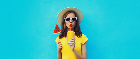 Summer portrait of young woman drinking juice with lollipop watermelon on blue background