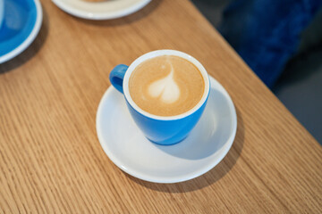 Overhead view of blue cup with coffee on the table