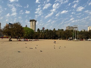 A beautiful sunny quiet day at Girgaon Chowpatty, Mumbai with pigeons and blue sky littered with clouds