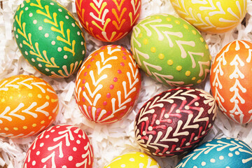 Handmade easter eggs. Vibrant color painted chicken eggs for celebrating easter holiday. Wicker...
