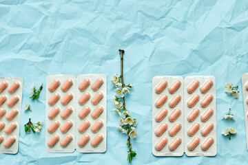 An artistic arrangement of medication with spring blossoms symbolizing health and renewal.