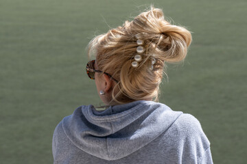 blonde girl with her back turned and her hair tied back