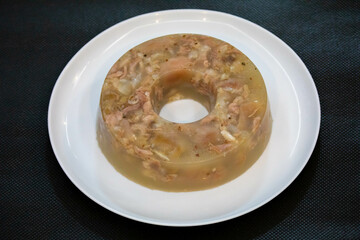 Traditional Ukrainian festive cold appetizer. Pork jelly with pieces of meat with parsley isolated on a white background. Drehlhi
