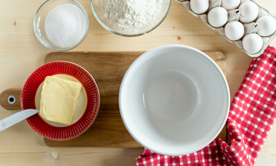 Ingredients for making dough or batter such as butter, flour, eggs, and sugar 