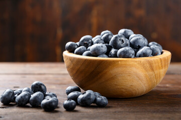 Fresh blueberries in a wooden bowl. Healthy and dietary food concept.