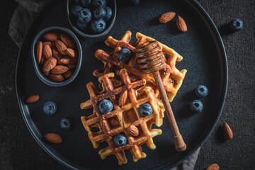 Homemade dark waffles made of berries, almonds and cocoa.