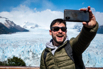 turista tomándose una selfie desde los miradores del Glaciar Perito Moreno, en la Patagonia...