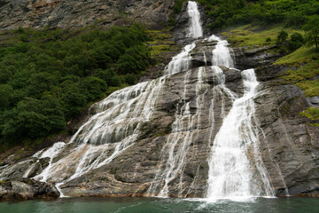 Fototapeta premium Waterfall seen when traveling on summer road trip in Norway.