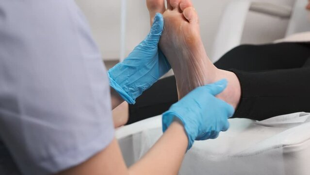 Masseur doing a professional foot massage in beauty salon.