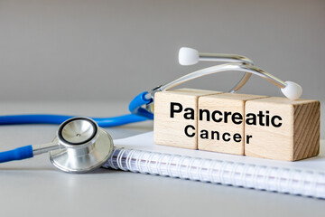 Pancreatic cancer, written on wooden blocks next to medical stethoscope, health concept, periodic...