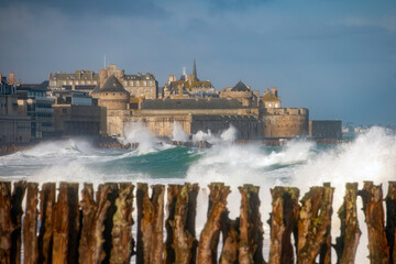 Tempête, vagues et grande marée sur la ville de Saint Malo en Bretagne, les fameux brise lames au premier plan - obrazy, fototapety, plakaty