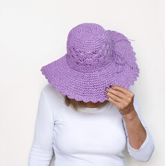 Woman with Head Down Holding Lavender Straw Hat