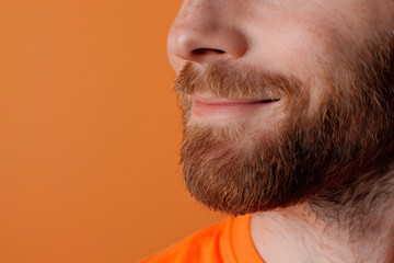 Obraz premium Close up of man with beard smiling against an orange background