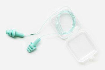 Reusable silicone earplugs mint color  in case, for swim, sleep, rest. Soft, flexible ear plug on string against noise, protect hear, close up object on white background, top view, flat lay