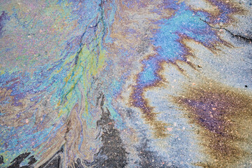 The vibrant texture of a petrol oil spill on a wet pavement.