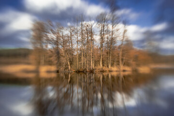 Landscape by a small lake in a forest in podlasie on a sunny,spring day with a blurred background.