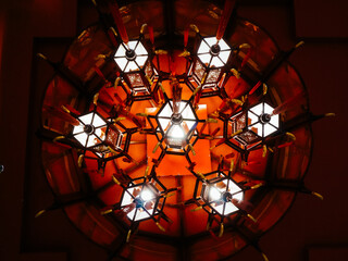 Ancient red chandelier from low angle perspective in a dark background