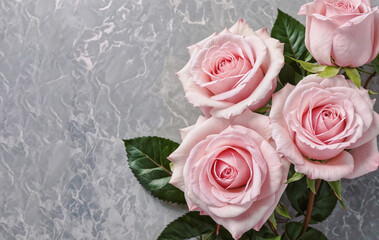 A bouquet of pink roses with green leaves on a grey  marble surface with copy space.