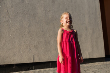 Child girl with hearing aids and cochlear implants having fun outdoor speak and playing. Copy space and empty place for advertising