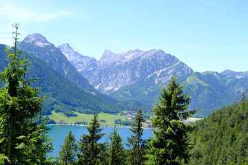 picturesque Achensee lake in Austria, yachts and boats on water, green mountains rises above calm...