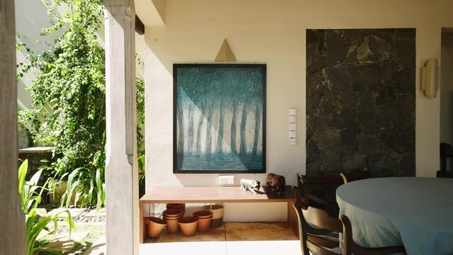 Abstract painting with blue trees in leaving room of retro villa on tropical island. Vintage picture art object on exotic resort with evergreen garden. Designer interior with furniture decorations.