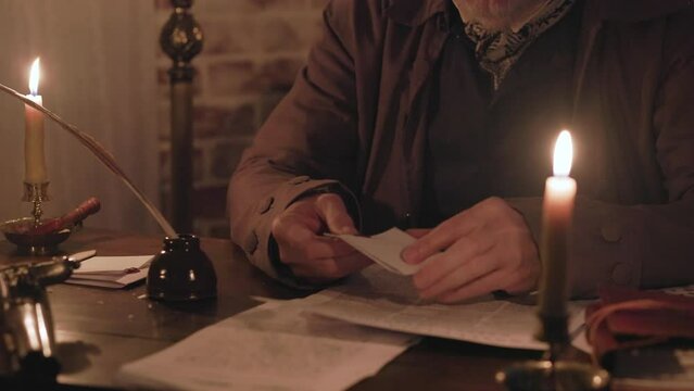 18th century man opens a wax sealed envelope and reads