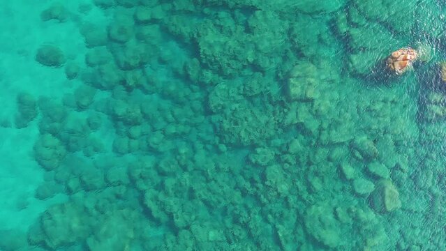 Abstract background of deep sea waves and stones, water ripples. Diving into the clear blue sea