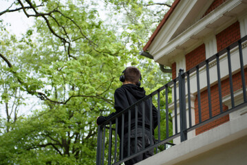 A young guy in headphones listens to music in nature. Poland, Zielona Gora