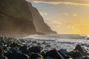Volcanic rock cliffs Achadas da Cruz in backlit sunlight. Waves of the Atlantic Ocean. Beautiful...