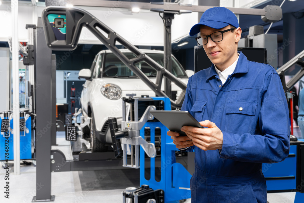 Poster serviceman with digital tablet on the background of the car in the car service.