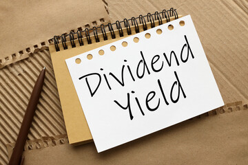 DIVIDEND YIELD craft notebook on a craft background. text on white page