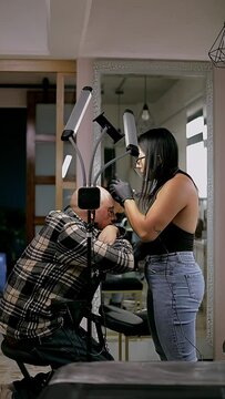 hair tattoo artist doing a scalp on a man's head in her studio