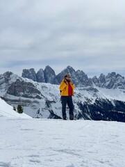 woman is standing infront of amazing mountains in winter in dolomites