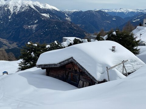 a snow covered wooden hut in the mountains in winter season