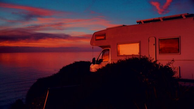 Camper rv camping on beach sea shore at sunrise. Adventure, travel with mobile home to Spain in wintertime.