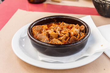 Stewed chicken gizzards in a sauce in a bowl on the table. Typical Spanish appetizer