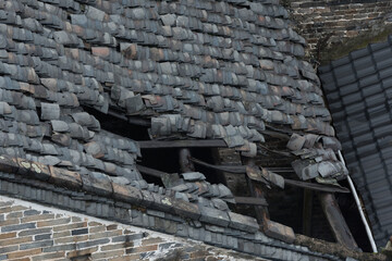 Holes in the tiled roof of an old Chinese house