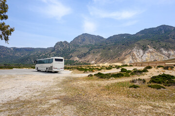 A tour bus on the road near the Stefanos crater on Nisyros island. Greece