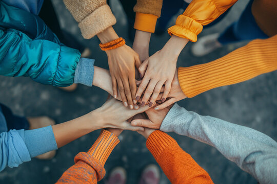 Group of Diverse Hands Together Joining Concept, top view of people putting their hands together. Stack of hands showing unity and teamwork.