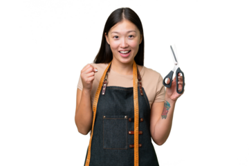 Young Asian seamstress woman over isolated background celebrating a victory in winner position