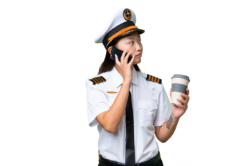 Airplane pilot Asian woman over isolated background holding coffee to take away and a mobile