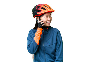 Young cyclist woman over isolated chroma key background keeping a conversation with the mobile phone with someone - obrazy, fototapety, plakaty