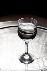 Glass of water on a wooden table. Selective focus. Toned.