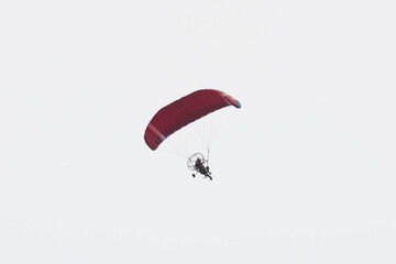 A propelled paraglider flies through the sky
