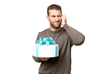 Young handsome blonde man holding birthday cake over isolated chroma key background frustrated and...