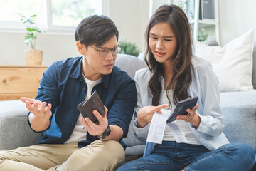 Stressed financial owe asian young couple love sitting stressed and confused by hand hold wallet...