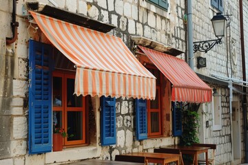 Wooden shutters and colorful awnings provide shade and privacy in Croatian coastal cafes. 